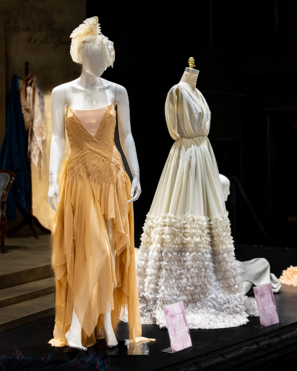 Mannequin wearing a gold-colored gown with shredded-looking skirt.