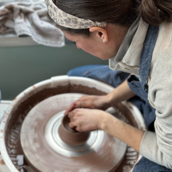 adult throwing at the pottery wheel at FYACS