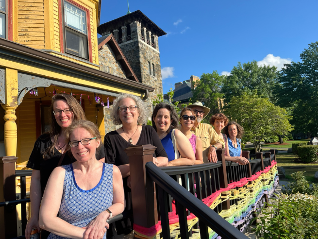 WritersinResBigYellow2024 (1) Eight writers-in-residence pose in front of Follow Your Art